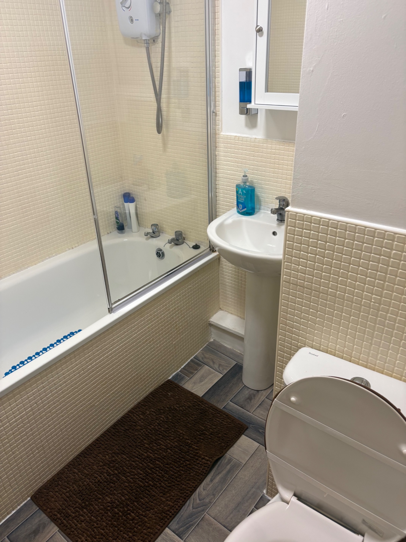 Clean bathroom with bath, shower screen, sink and fresh floor area