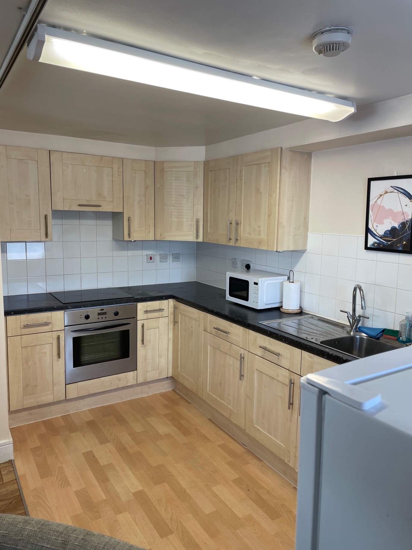 Kitchen after the turnover clean with clear worktops and floor